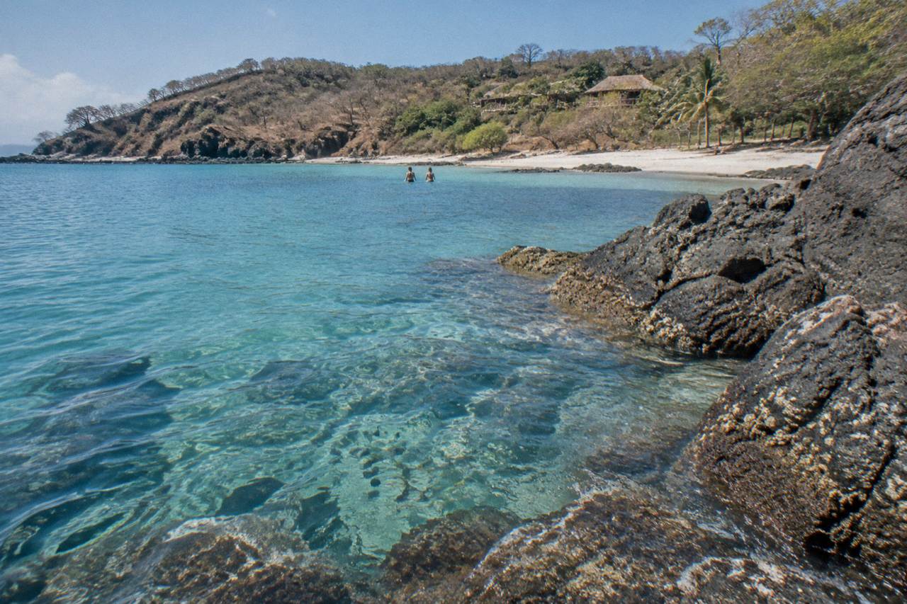 Clear turquoise water over a rocky Pacific cove with reef fish below the surface