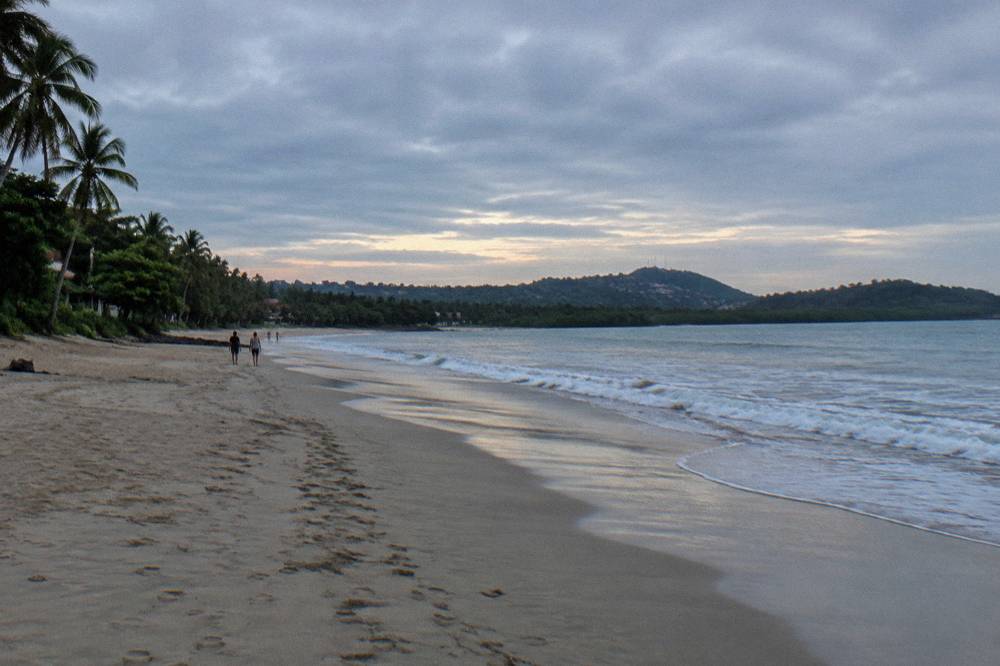 Long sandy beach at morning with gentle breaking waves and no people