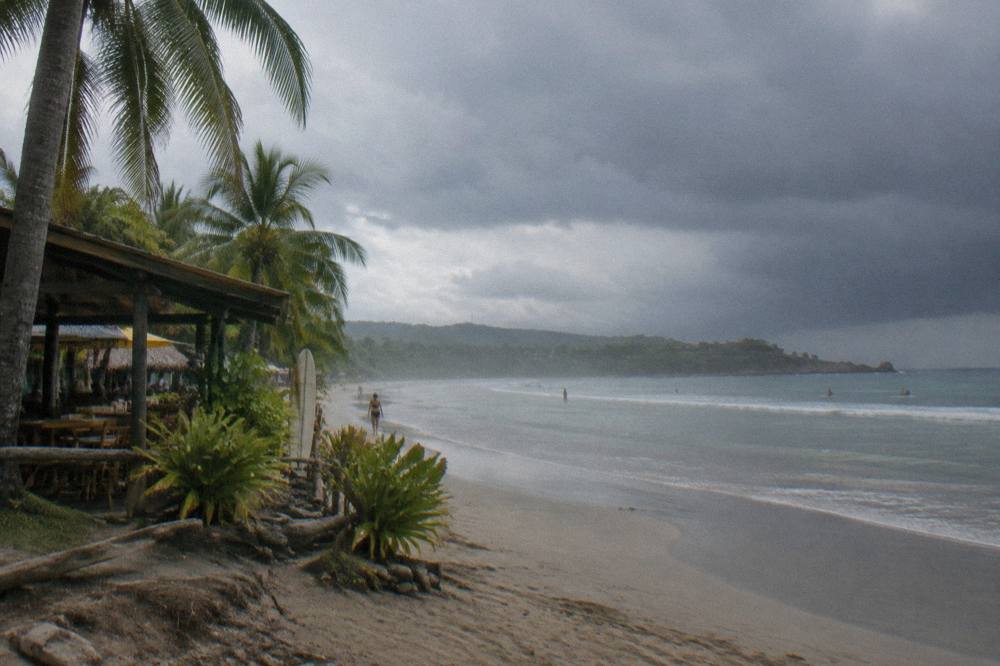 Dark rain clouds over the Pacific ocean beyond a calm Tamarindo bay