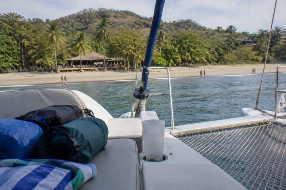 Dry bags and towels packed on a bench aboard a catamaran