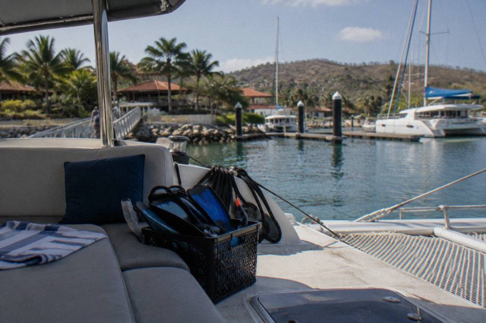 Catamaran deck with snorkel gear and shaded seating on a sunny afternoon