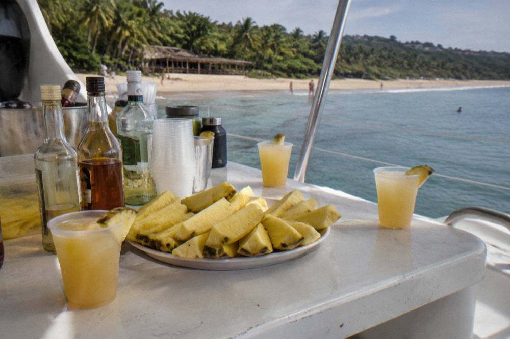 Open bar drinks and fresh fruit arranged on a catamaran table