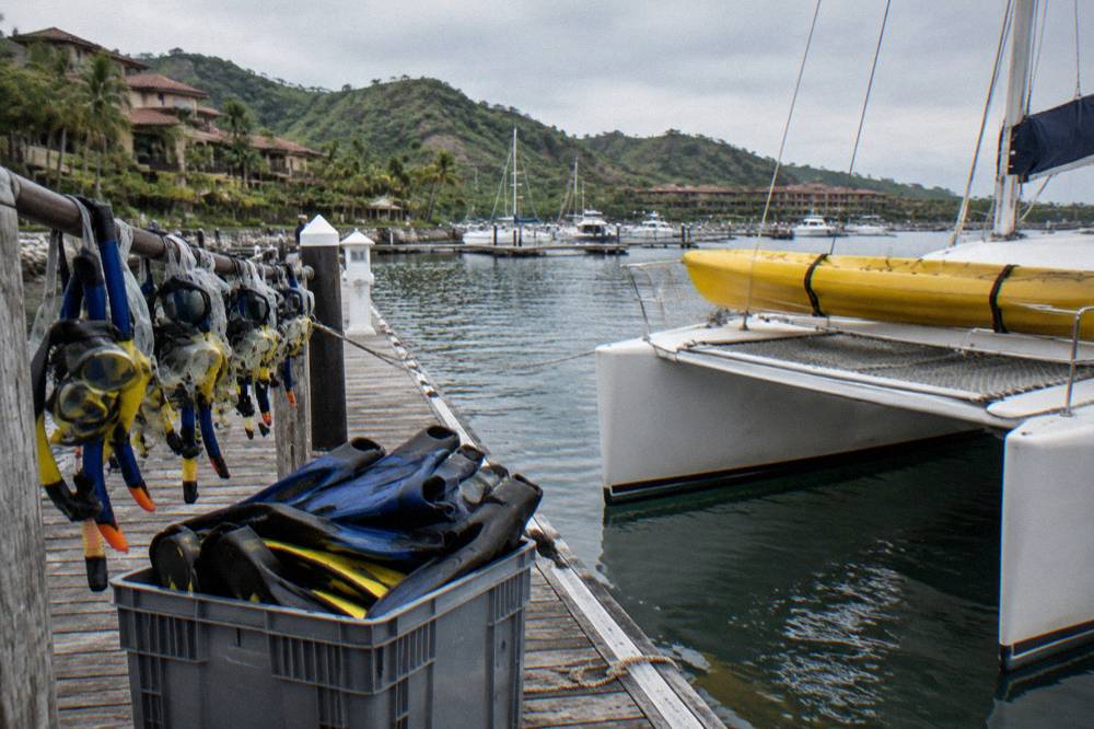 Snorkel masks, fins and kayaks stowed on a catamaran deck