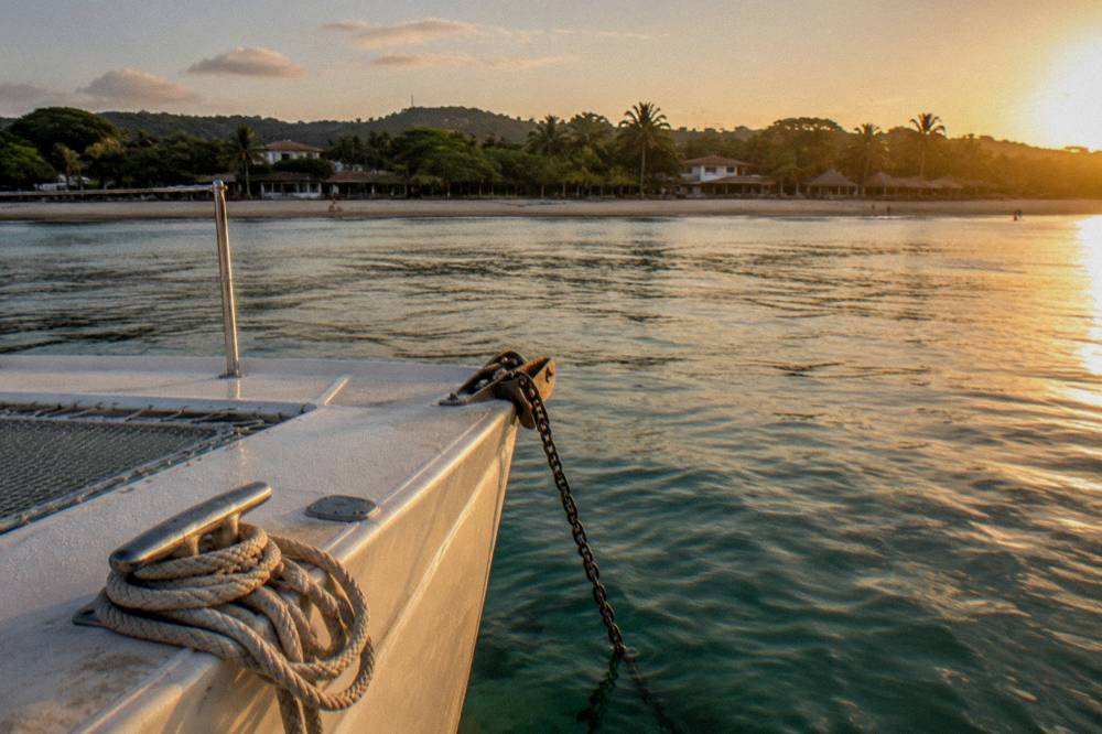 Anchor line and cleat on a catamaran bow in golden light
