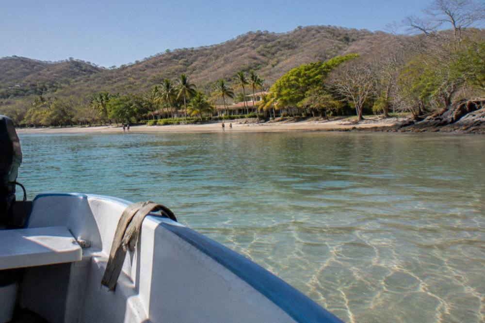 Quiet cove with clear water and forested hills seen from a moored boat