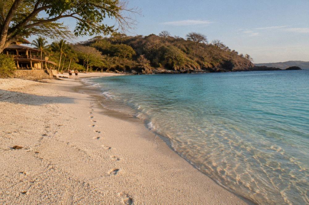 A white sandy cove on the Guanacaste coast in late afternoon with calm turquoise water